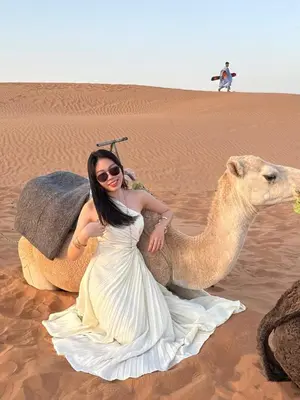a woman is sitting on a camel in the desert at Merzouga luxury tente in Merzouga