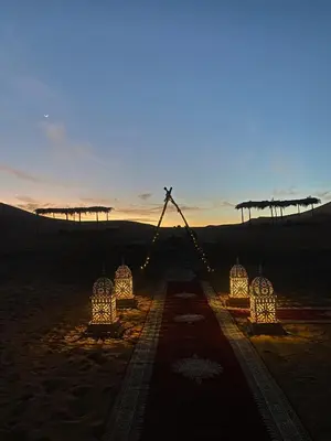 a group of lights in the desert at sunset at Merzouga Unique Standard Camp in Merzouga
