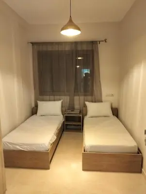 two beds in a small room with a window at NEW Luxury & Equipped Dalia , 2 bedrooms living room in Tiflet
