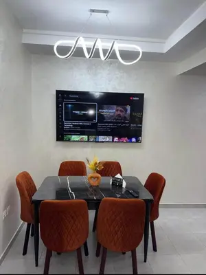 a dining room with a table with chairs and a tv at Alyassamine in Taza