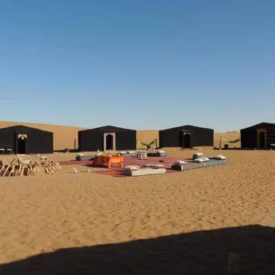 a group of tents in the middle of a desert at Excursion Erg chegaga in Mhamid