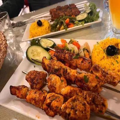 a plate of food with meat and vegetables on a table at Africa Berber Camp in Merzouga