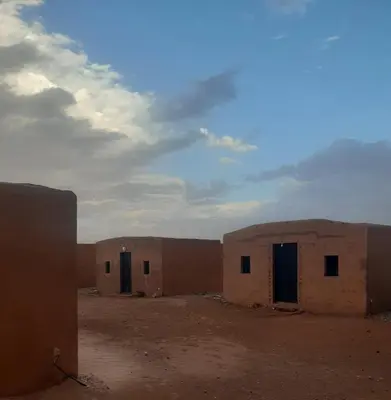 a group of buildings in the middle of the desert at Sahara Peace camp in Zagora