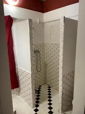 a shower with a glass door in a bathroom at Riad Bleu Afriqua in Boumalne