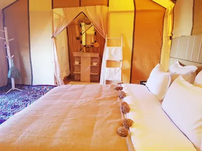 a bedroom with a large bed in a tent at Erg Chebbi Camp in Merzouga