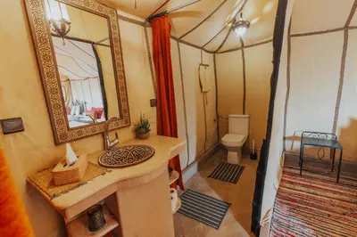 a bathroom with a sink and a mirror in a room at Tassili Luxury Desert Camp in Merzouga