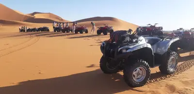 an atv parked in the sand in the desert at Erg Merzouga Desert Camp in Merzouga