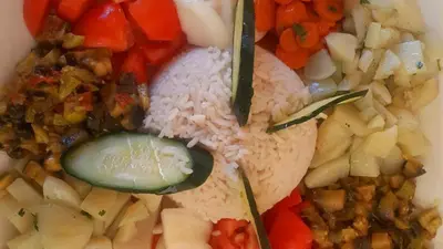 a plate of food with rice and vegetables at Camp Sahara Majestic in Mhamid