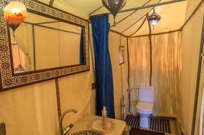 a bathroom with a shower with a toilet and a mirror at sand rose luxury camp in Merzouga