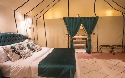 a bedroom with a bed in a tent at Sultan Luxury Camp in Merzouga