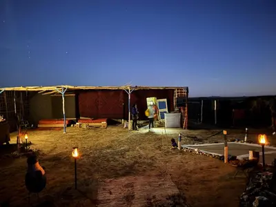 a tent with lights in a yard at night at Travel Oasis Merzouga Camp in Merzouga