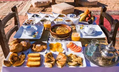 a table full of breakfast food on a purple table at Bedouin Desert Camp in Merzouga