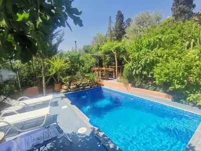a swimming pool in a yard with chairs and trees at Charming Apartment in Fès - 30 m² + View in Fès