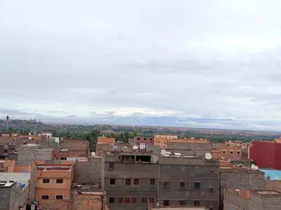 a city with buildings and mountains in the background at Hostel Afgo Rooftop in Ouarzazate