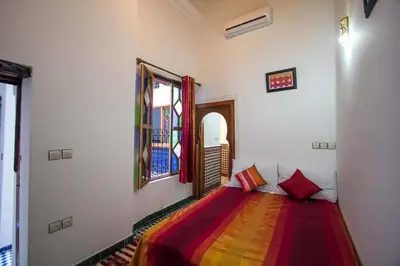 a bedroom with a bed with a colorful blanket at dar Benfares rcif in Fès