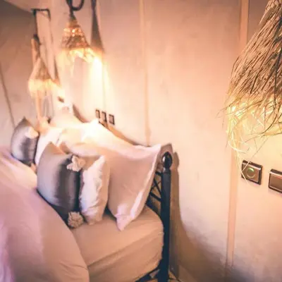 a bedroom with a bed with pillows on it at Merzouga Horizon Luxury Camp in Merzouga