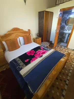 a bedroom with a large bed with flowers on it at RIaD DRISSIA Panoramic in Fès