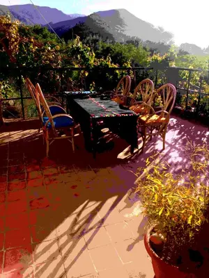a table and chairs on a patio with a view at Gte Tawada - Valle Heureuse - Chambre pour 4 Personnes in Agouti