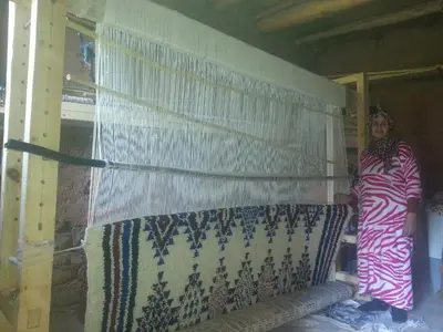 a woman standing next to a wall with a curtain at Gte Tawada - Valle Heureuse - Chambre pour 2 Personnes in Agouti