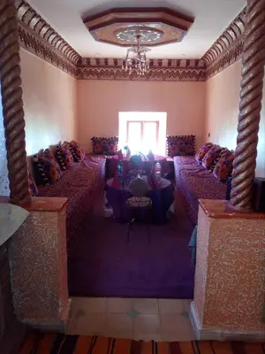 a room with rows of tables and a chandelier at Gte Tawada - Haut-atlas - Chambre pour 3 Personnes in Agouti