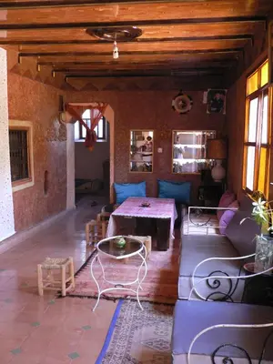 a living room with a couch and a table at Gte Tawada - Haut-atlas - Chambre pour 3 Personnes in Agouti