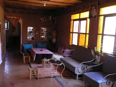 a living room with a couch and a table at Gte Tawada - Haut-atlas - Chambre pour 3 Personnes in Agouti