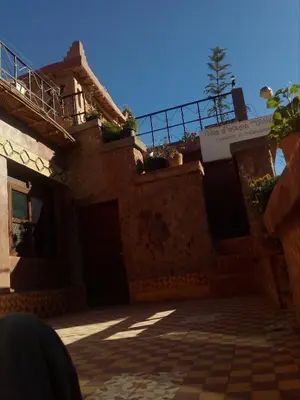 a house with a porch and a balcony on top of it at Gte Tawada - Haut-atlas - Chambre pour 4 Personnes in Agouti