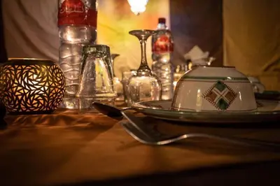 a table with a plate and glasses on a table at Desert Luxury Camp in Mhamid