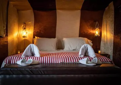a bedroom with a bed with hats and towels on it at Desert Luxury Camp in Mhamid