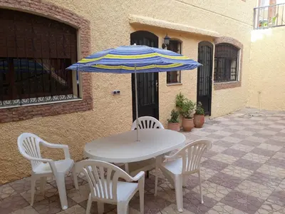 a table and chairs with an umbrella on a patio at The Orchard Comfy & Cozy Apartment 2 in Ifrane
