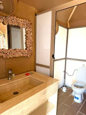 a bathroom with a wooden tub and a toilet at Hotel ksar merzouga in Merzouga