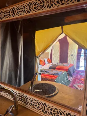 a view of a tent with a table and a sink at Hotel ksar merzouga in Merzouga