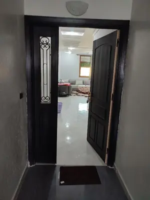 a hallway with a black door and a living room at The good stay 3 in Midelt