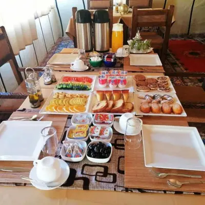 a table with many trays of different types of food at Local Luxury Camp in Merzouga