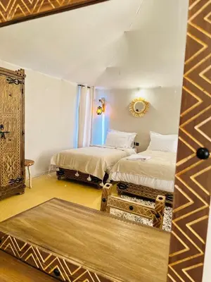 a room with two beds and a mirror at Merzouga Top Luxury Camp in Merzouga