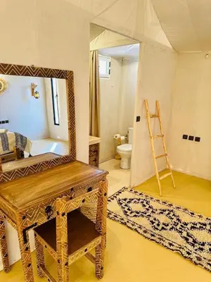 a bathroom with a mirror and a wooden dressing table at Luxury Camp Merzouga & Activities in Merzouga