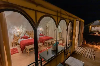 a bedroom with two beds in a room with arches at Luxury Camp Merzouga & Activities in Merzouga
