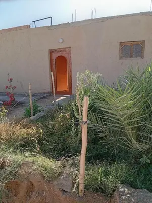 a wooden cross in front of a house at Guest House familly takojt in Merzouga