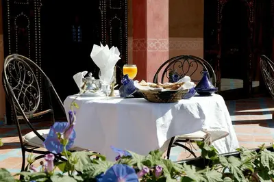 a white table with a basket of food on it at Chez Le Pacha - Authentic Sahara Hotel Mhamid in Mhamid